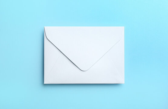 White paper envelope on light blue background, top view