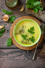 Spinach soup with cream on a rustic wooden table. Top view flat lay background. Copy space.