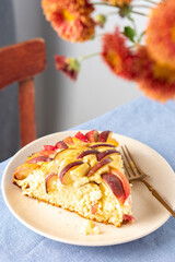 Delicious apple pie, a serving of apple pie on a plate with a fork, home interior, table with blue tablecloth, vase with autumn flowers chrysanthemums