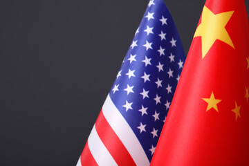 Fototapeta premium Closeup view of USA and China flags on dark background, space for text. International relations