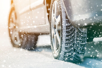 Close-up of car wheels rubber tires in deep winter snow. Transportation and safety concept. - obrazy, fototapety, plakaty