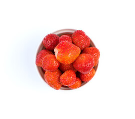 Strawberries in a white Cup isolated on a light background. Berry background, top view. The concept of natural products.