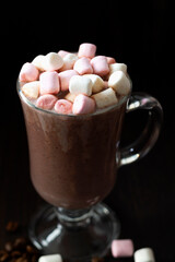 cup of coffee with marshmallows. glass of cappuccino on a dark table. hot chocolate on a wooden background. hot drinks winter and autumn. vertical. copy space