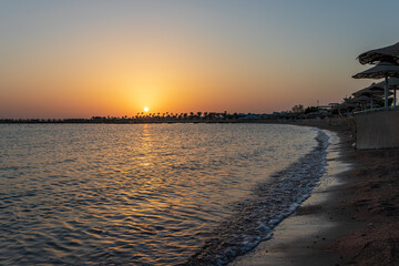 Sunrise on the beach with parasol overlooking the Red Sea in Hurghada, Egypt