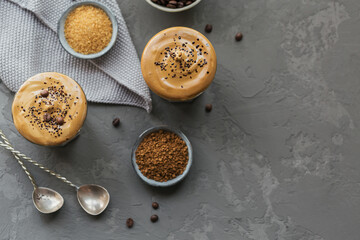 Dalgona whipped coffee, instant, cream, iced coffee. Cocktail with coffee, milk and ice cubes on grey background mockup. Trendy drink background with copy space for text.