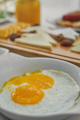 At the breakfast table fried egg, sunny side up and breakfast foods. Fresh, healthy, light breakfast