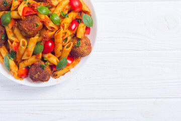 Italian penne pasta with meatballs and tomatoes