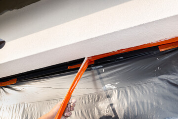 A newly applied layer of silicone plaster on the window jamb, the window is secured with black...