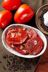 .Sun-dried tomatoes in a bowl with olive oil. Top view.