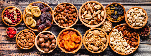 Various Nuts and dried fruits in wooden bowls.