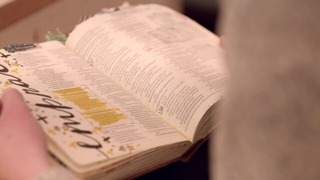 Girl flipping through pages of a book or bible. Beautifully decorated book.