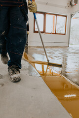 A worker applies the primer to the concrete floor.Epoxy resin project