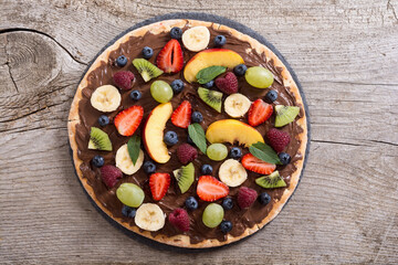 Fruit pizza with nut nougat cream , fruit and berries
