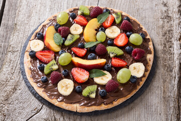 Fruit pizza with nut nougat cream , fruit and berries