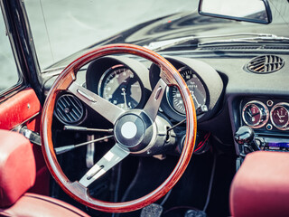 The steering wheel and dashboard of an antique classic car
