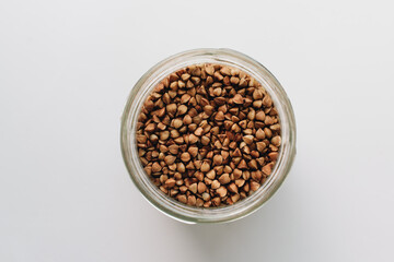 Scatterd raw buckwheat on white background