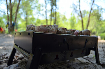photo of meat on the grill on the beach