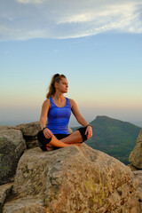 young beautiful girl meditating girl on the mountain