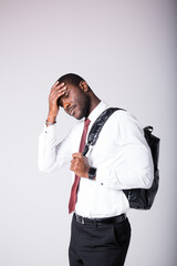 Portrait of a black student standing on a white background and holding his head with his hand