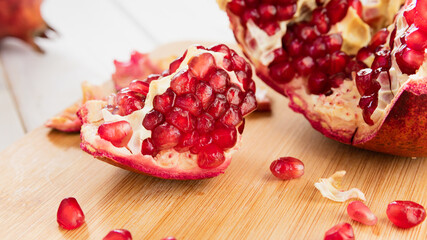 ripe red pomegranate on a white wooden table
