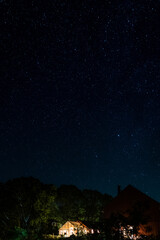 Fototapeta na wymiar night sky with stars over an illuminated greenhouse in the swedish countryside