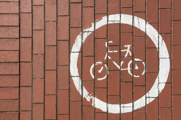 Bicycle path sign printed on on the sidewalk.