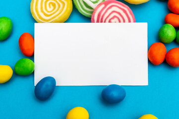 Blank card with multi colored candies on blue. Space for text.