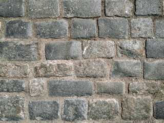 Texture of gray granite paving stones, top view. Background from natural block stone.