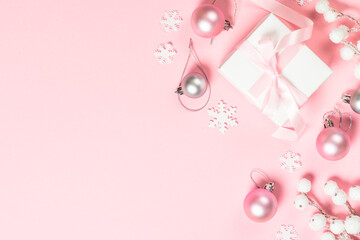 Christmas present box and decorations on pink background.