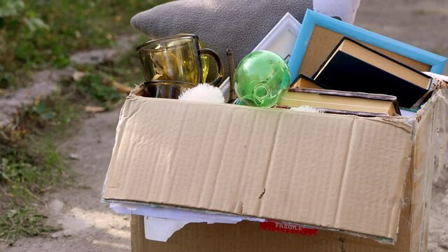 Close up box with old items. Garage sale in the yard. Searching for goods. Decluttering a house