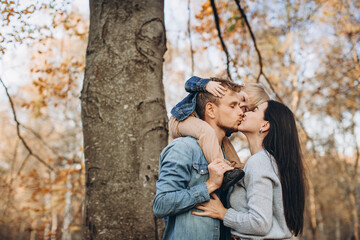 Family playing in autumn park having fun.
