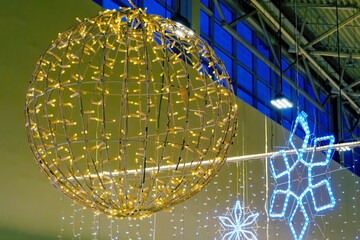 Sphere from garland hanging in shopping center, luminous decoration in mall. Selective focus, Christmas ornaments