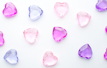 Pink and purple hearts crystals on white background