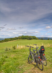 Obraz premium Two bikes standing in the grass with a view