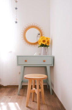 Scandinavian Home Interior with Painted Mint Table, Sunflowers and Stylish Wooden Chair. Concept of modern home interior.