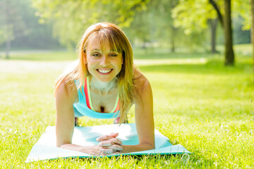 Woman holding plank pose outside