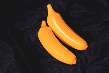 Two bright bananas on a dark background.
