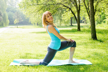 Smiling woman stretching in park