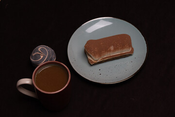 Morning breakfast of coffee and sweet marshmallows and tiramisu on dark background. Delicious breakfast