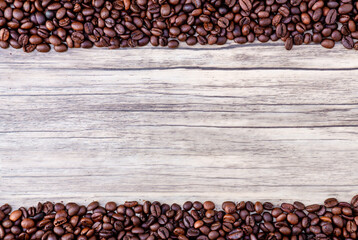 Coffee beans on wooden background. Pile of coffee. Coffee beans on a wooden background. Top view. Copy space. - Powered by Adobe