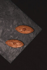 Two almond biscuits on a stone slab. Tasty food