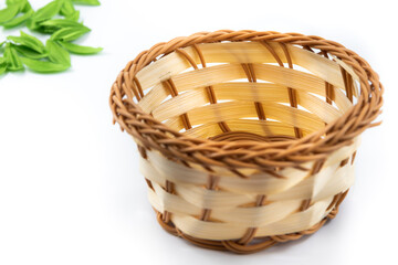 Photo of a wicker basket with leaves on a white isolated background