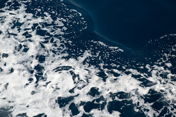 Waves and white foam at the sea. Watching the blue water building pattern.