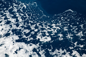 Waves and white foam at the sea. Watching the blue water building pattern.