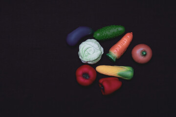 Miniatures of vegetables, fruits and berries on a white background. Plastic toy