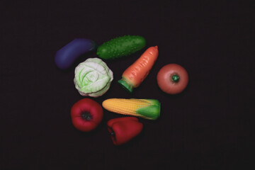 Miniatures of vegetables, fruits and berries on a white background. Plastic toy