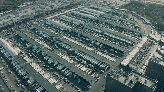 Aerial view of a big logistics centre full of trailer trucks at warehouse bays