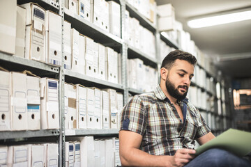 Man works in archive and reviews the different files