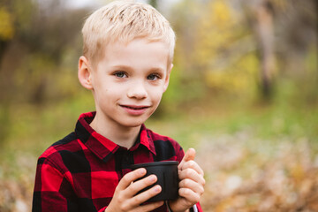 Portrait of charming boy with thermos cup