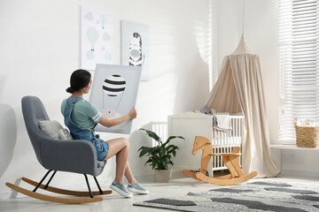Decorator with picture sitting indoors. Children's room interior design